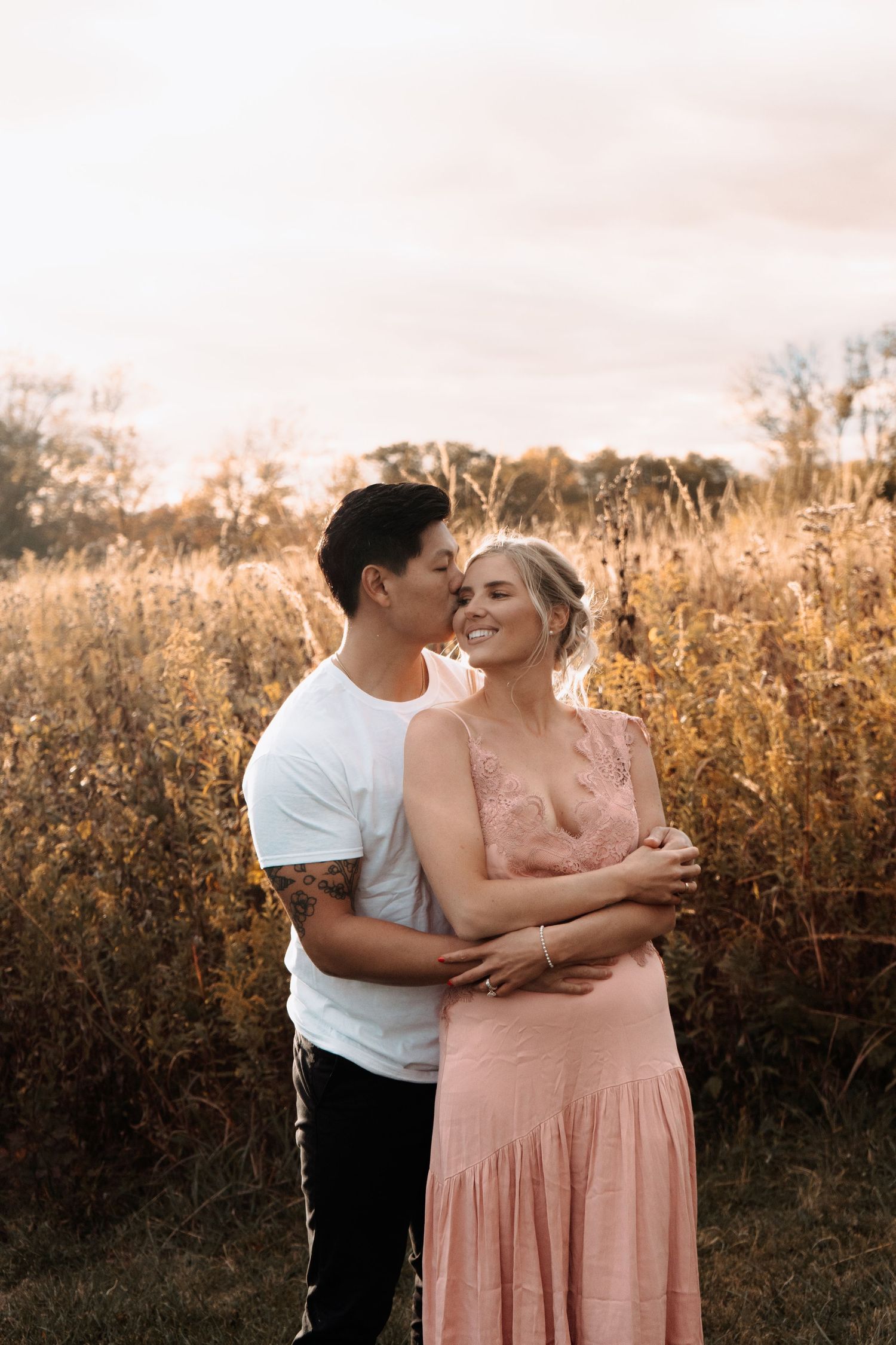 A romantic sunset moment in a golden field with tall grass and warm lighting.