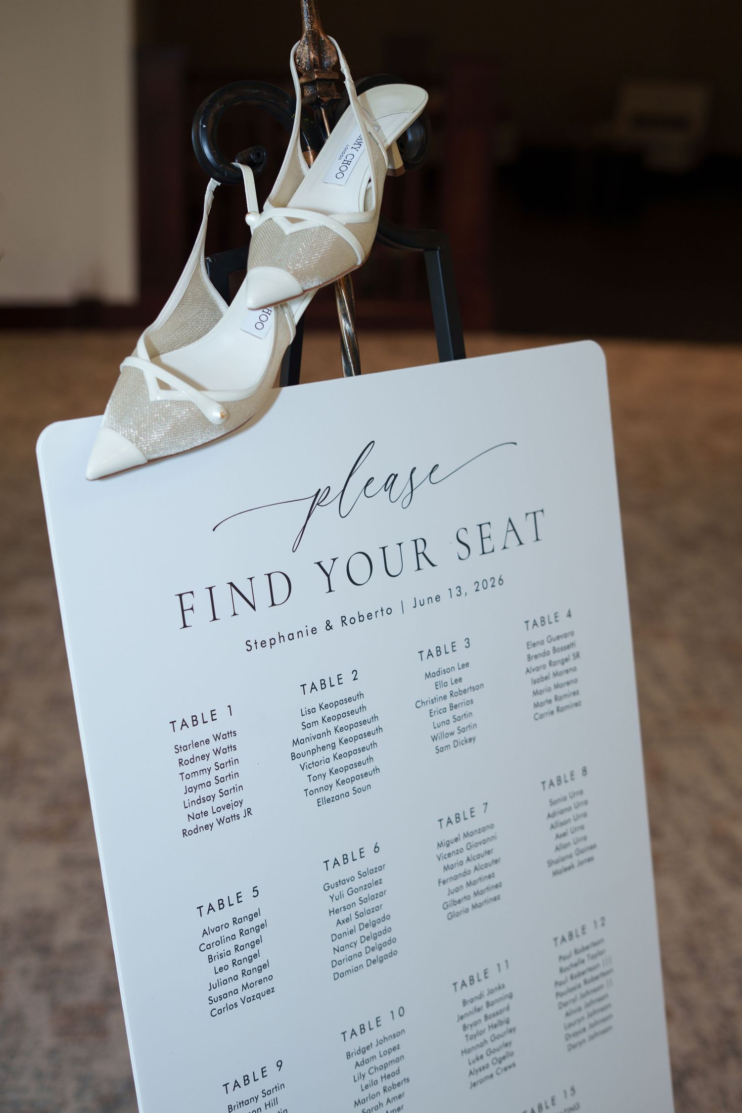 Wedding seating chart sign reading Find Your Seat for Stephanie & Roberto, June 13, 2024, with bridal heels on top.