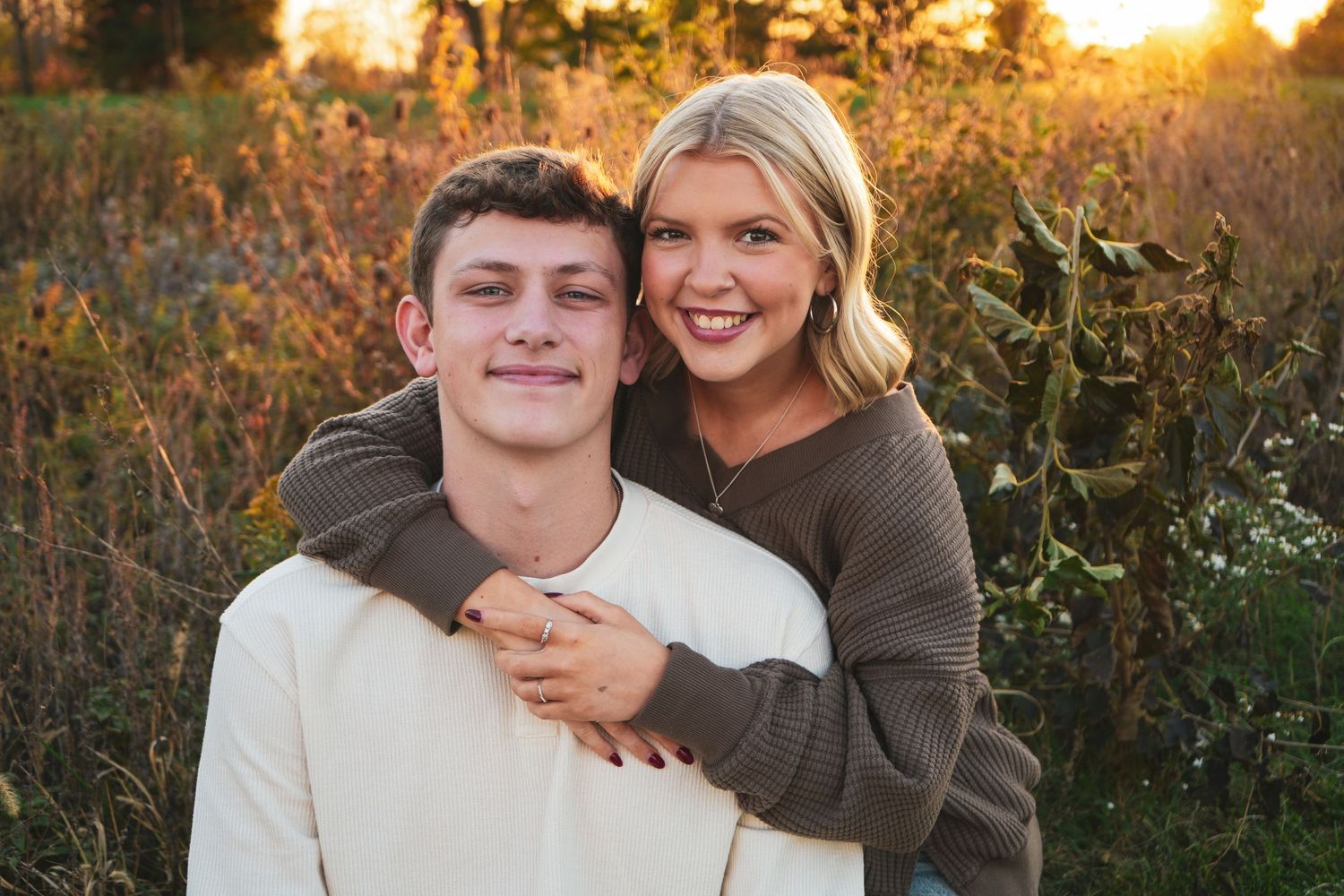 A sunset engagement photoshoot with warm autumn colors in a natural outdoor setting.