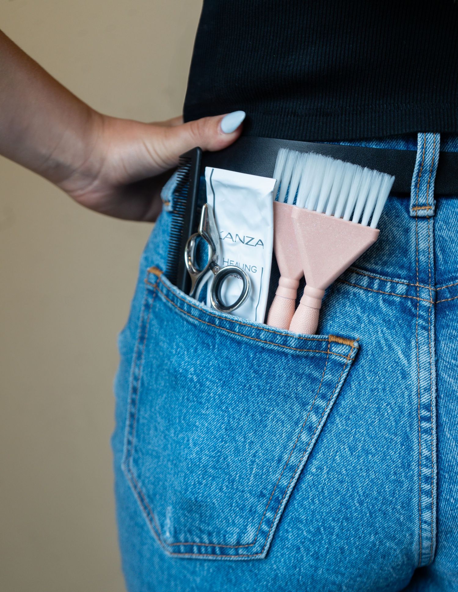 Hands tucking money and credit cards into pockets of blue denim jeans.