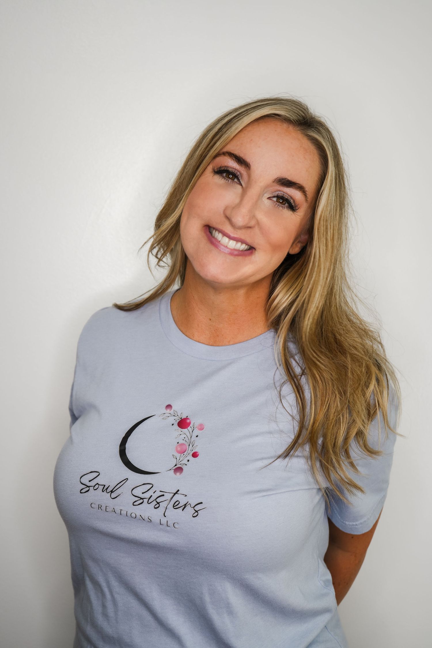Woman wearing light blue t-shirt with 'Soul Sisters' and moon design smiling in multiple poses against white background.