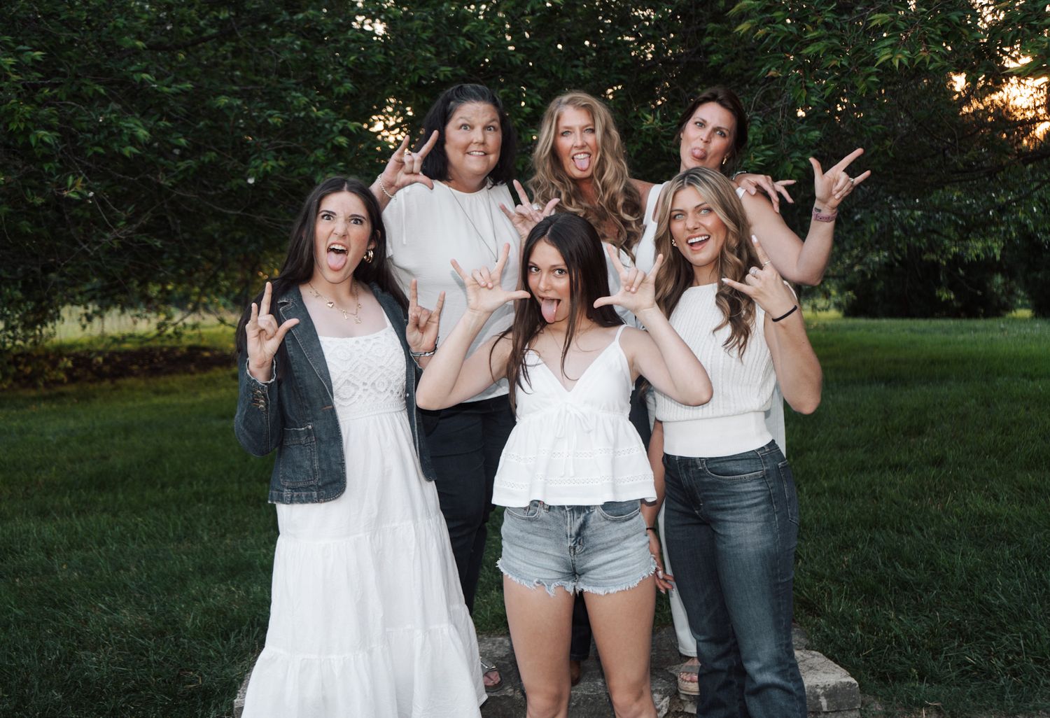 Group of friends posing playfully together outdoors at sunset.