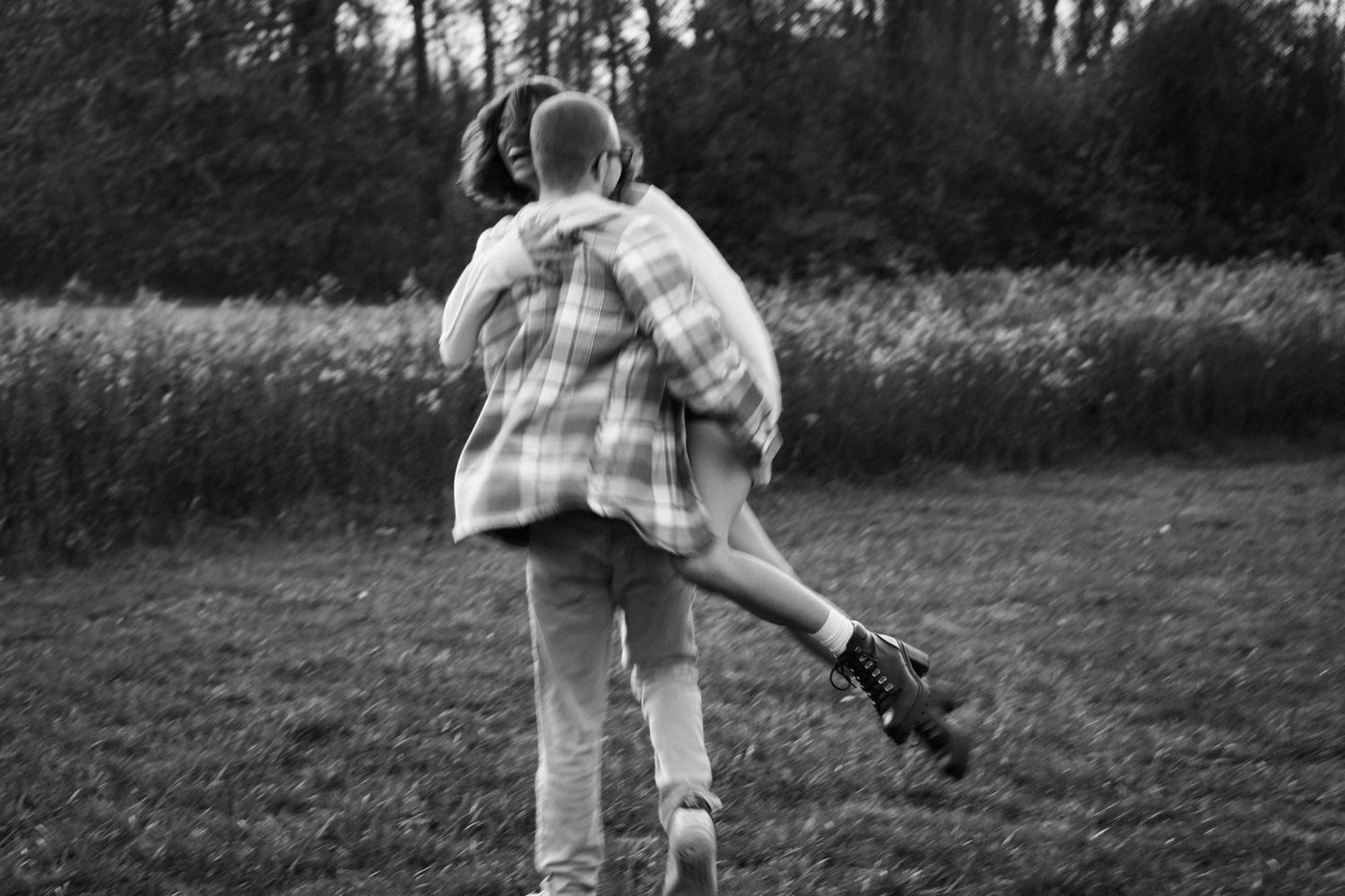 Black and white sequence showing a playful couple dancing in a field.
