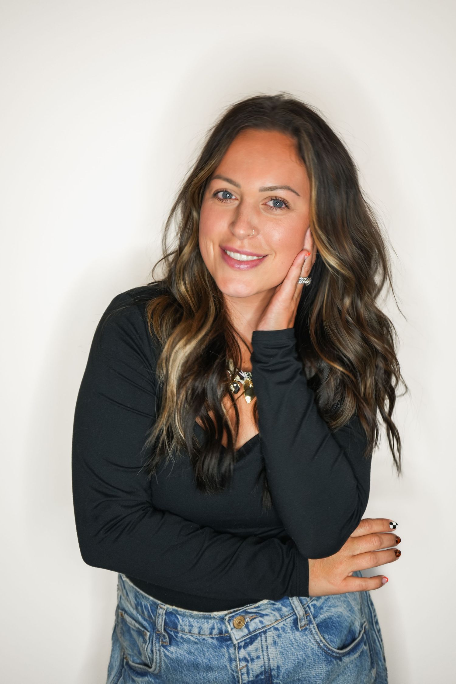 A series of casual portraits showing someone in a black sweater and jeans posing playfully against a white background.