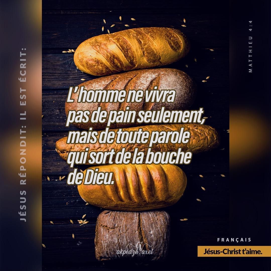 Fresh baked bread loaves on dark wood with French biblical quote text overlay about living by God's word.