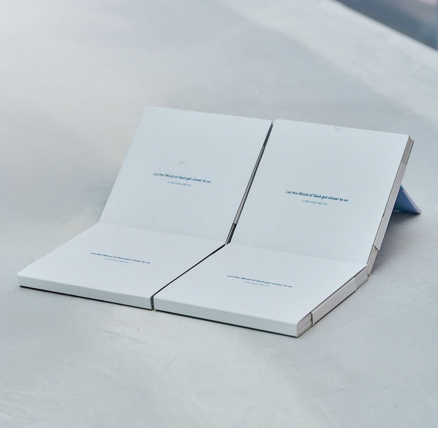 Open white book or pamphlet on light gray surface. Verset biblique illustré - illustrated biblical verse - akpedzeaxel