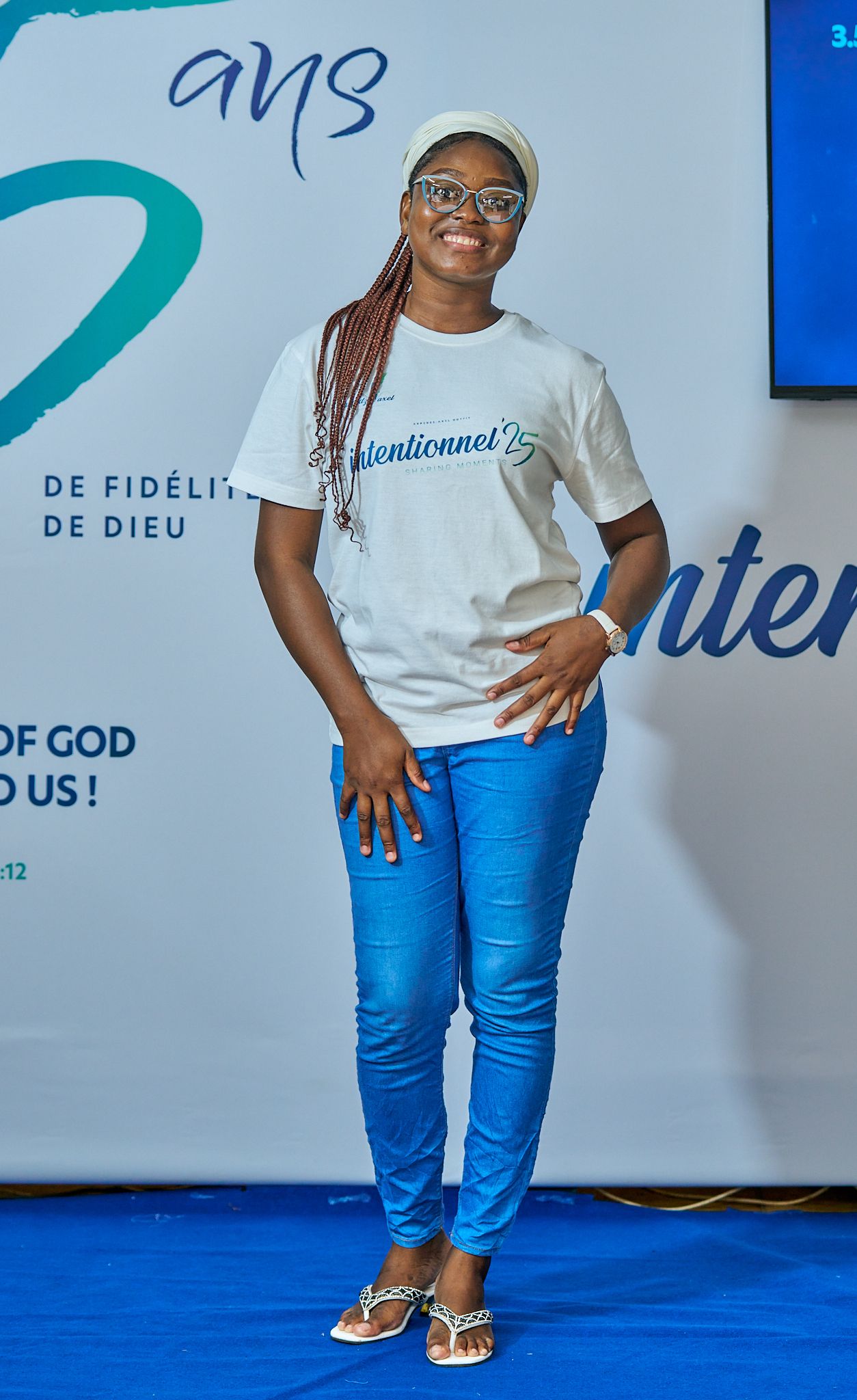 Casual poses of person in white t-shirt and blue jeans against branded backdrop during sharing moment called intentionnel