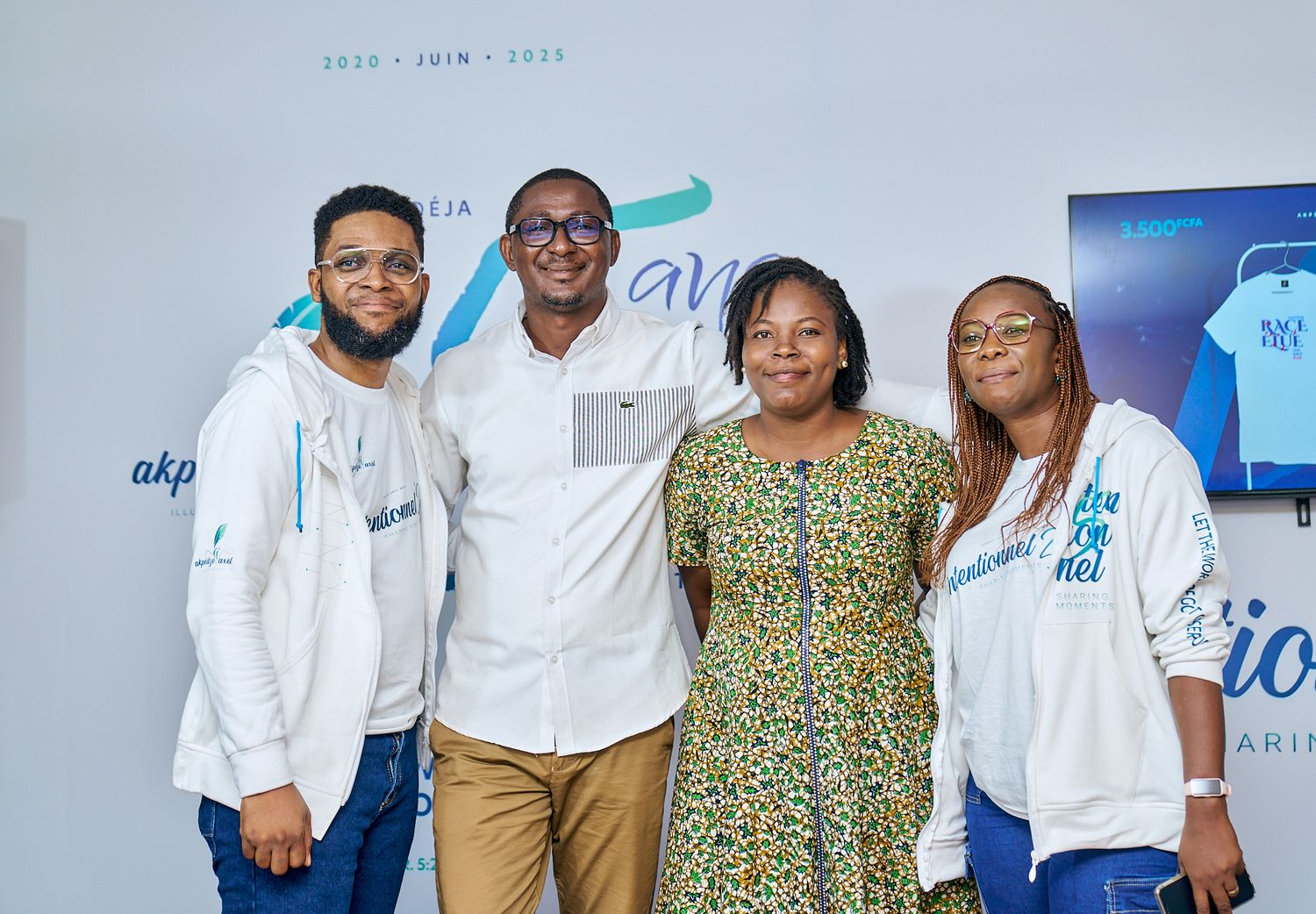 Group photo of people in white shirts and blue jeans standing together at sharing moment called intentionnel with blue and white backdrop.