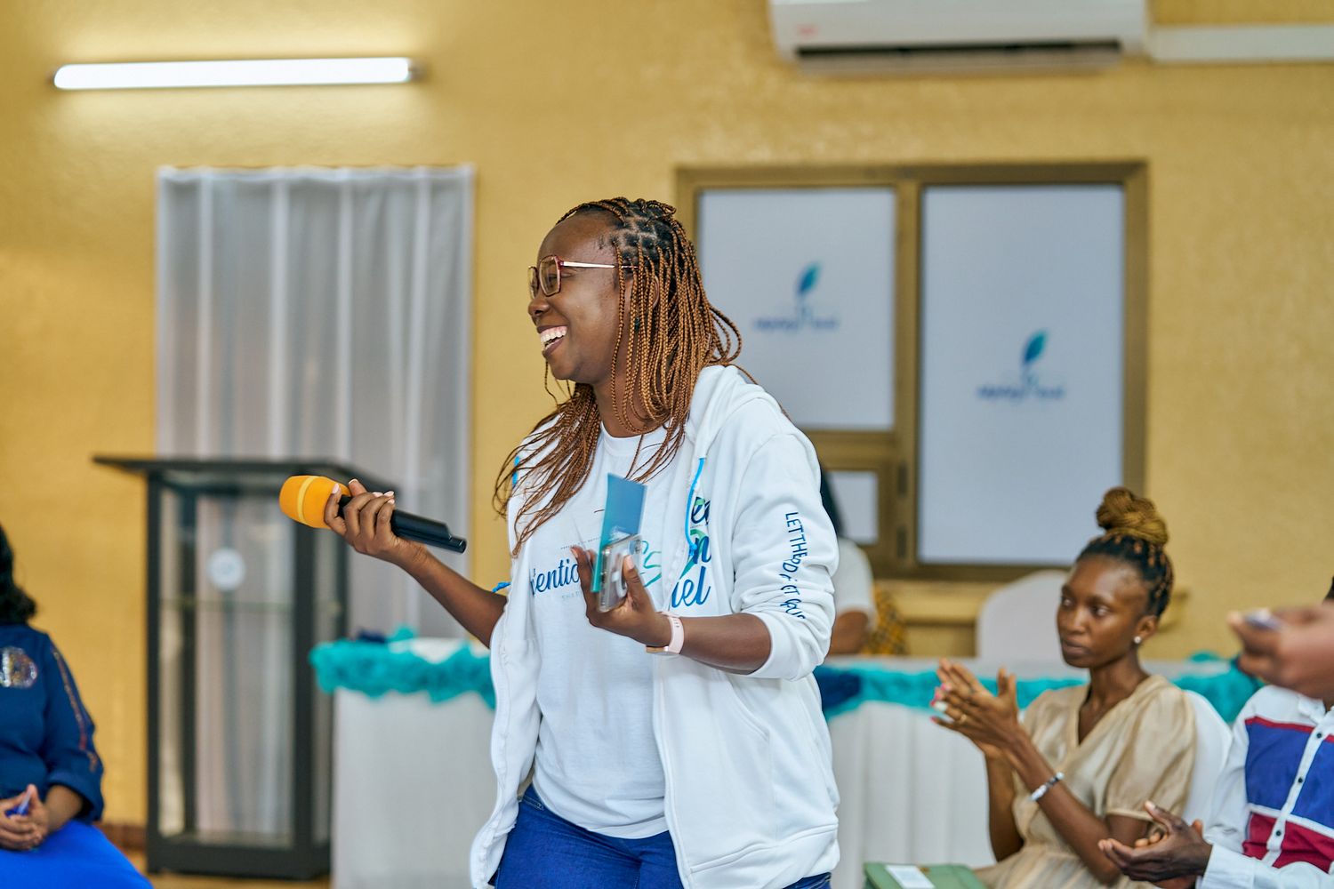 Group of attendees participating in a sharing moment called intentionnel with blue and green balloon decorations.