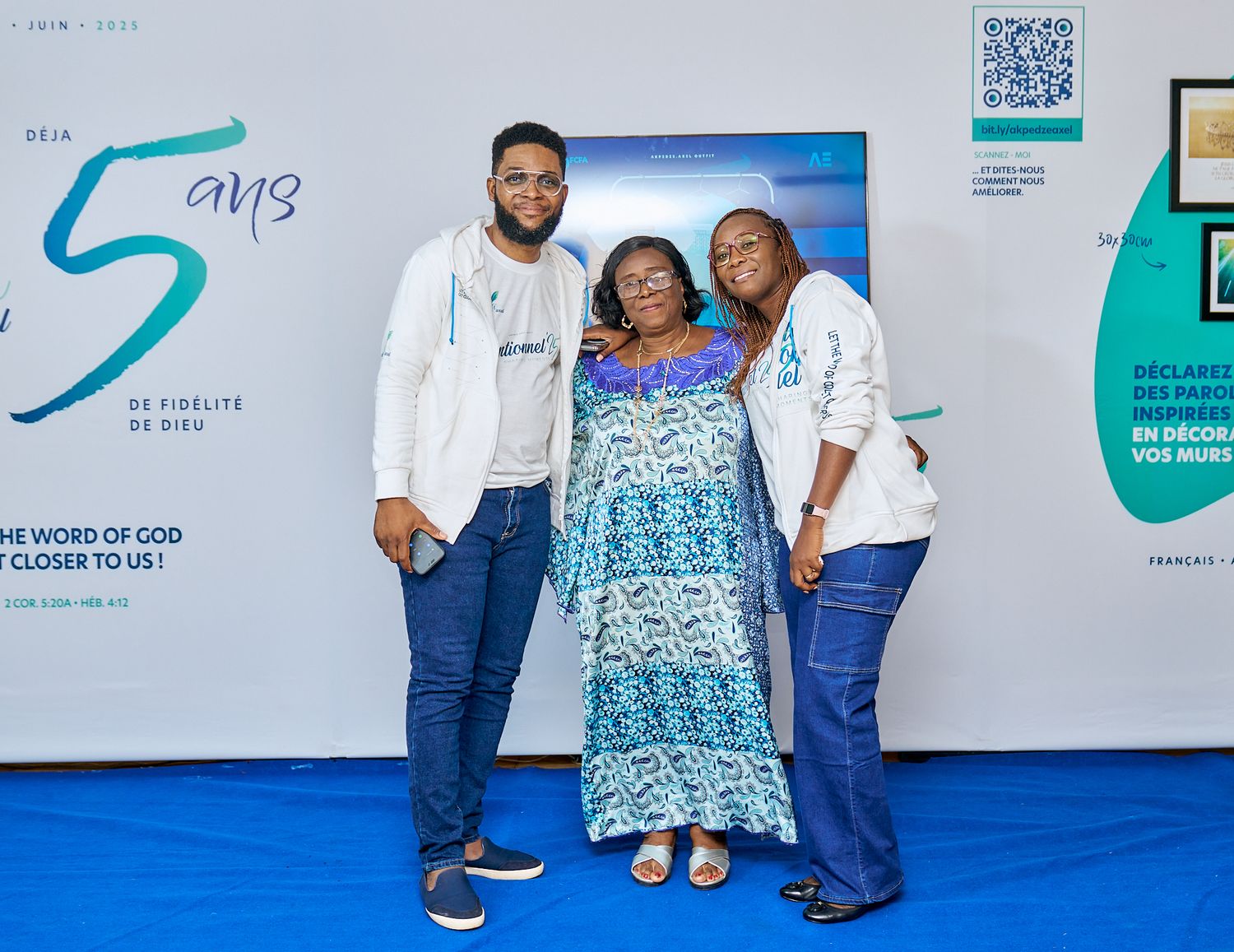People posing together at sharing moment called intentionnel with blue and white branded wall backdrop.