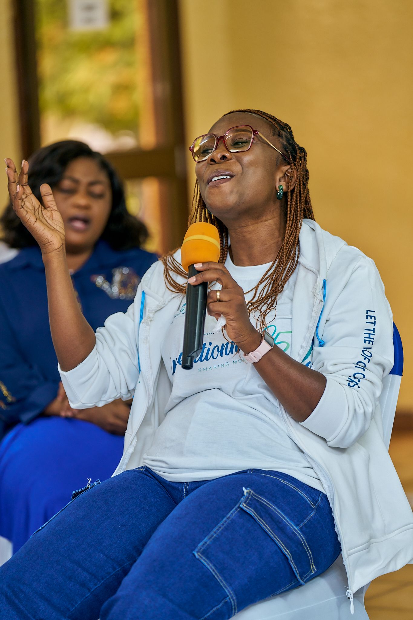 Person in white sweatshirt with microphone enjoying moment during sharing moment called intentionnel