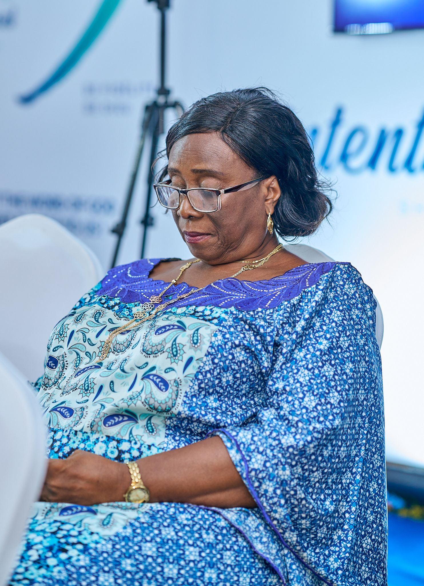 Person wearing blue floral print dress in office setting at sharing moment called intentionnel