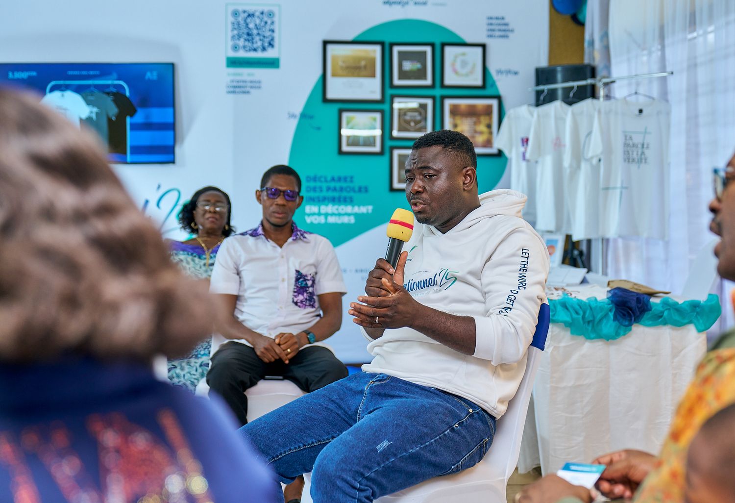 Group discussion at indoor event, a sharing moment called intentionnel with white chairs and framed artwork on wall.