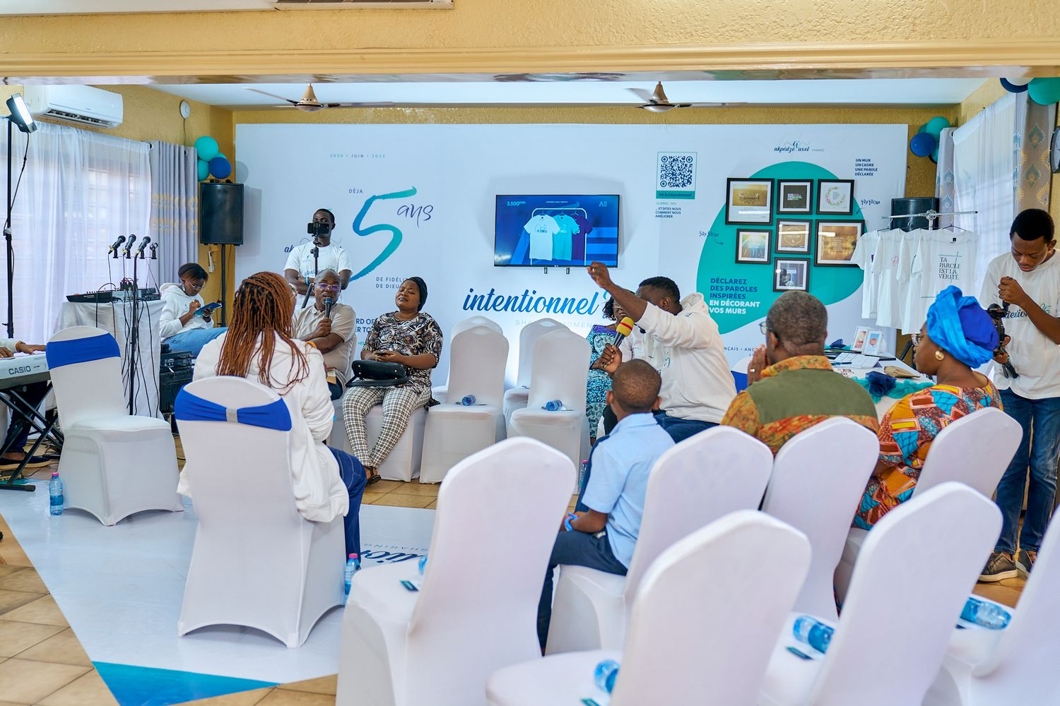 Conference room setup with white chair covers and presentation materials on display during sharing moment called intentionnel