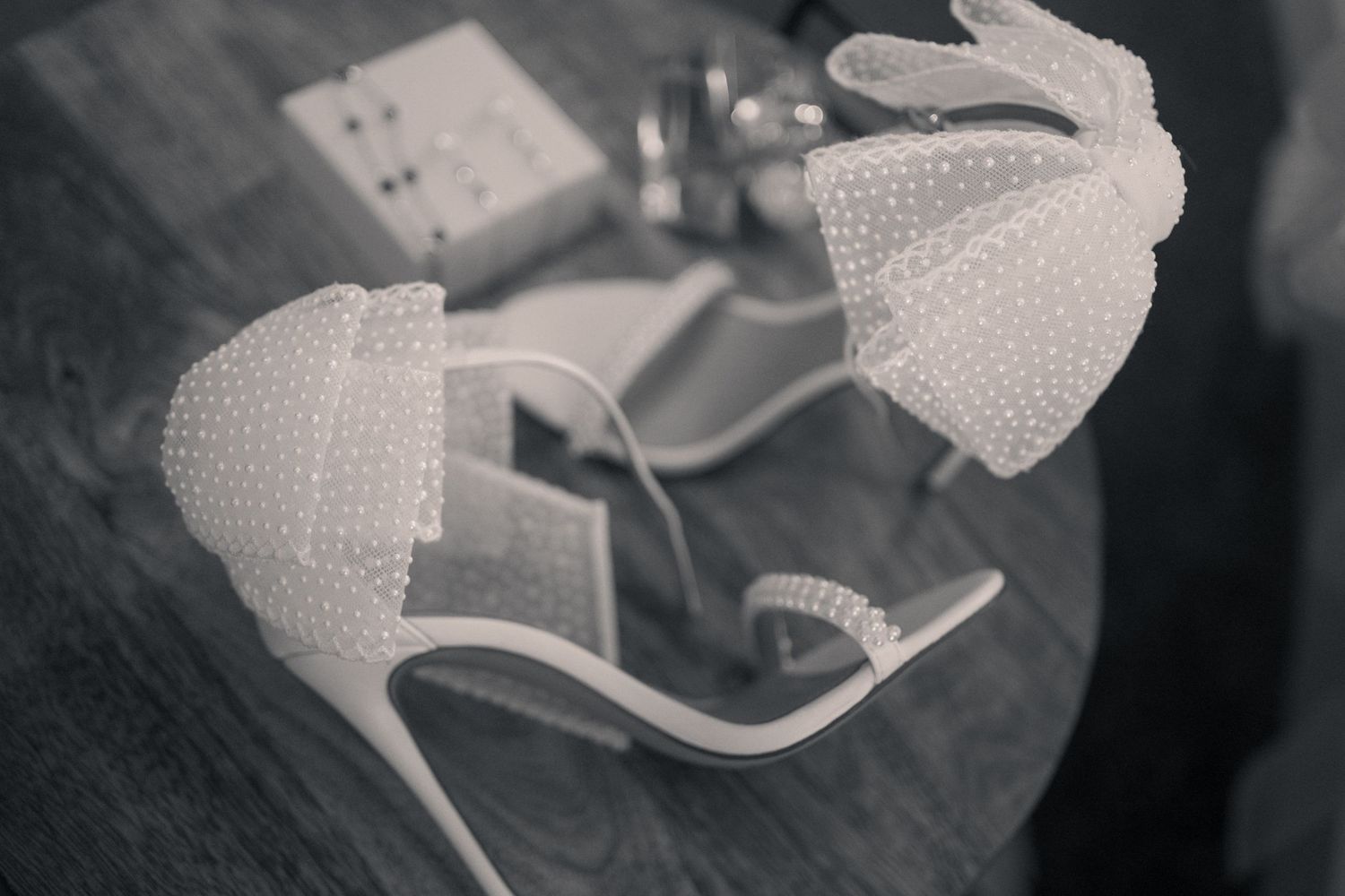 Close-up artistic black and white photos showing delicate details of bridal shoes with polka dot mesh fabric.