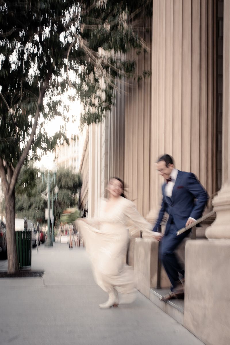A playful sequence of a couple jumping and posing near classical building columns.