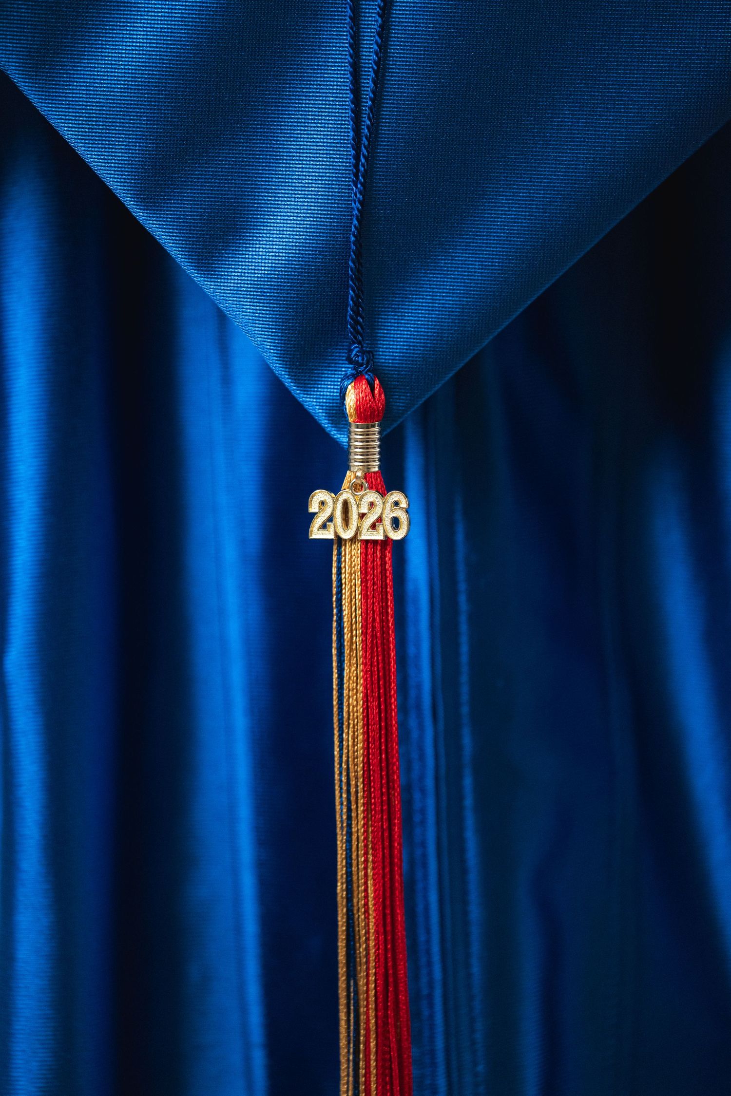 Blue graduation cap with a 2026 tassel in red and gold, symbolizing academic achievement.