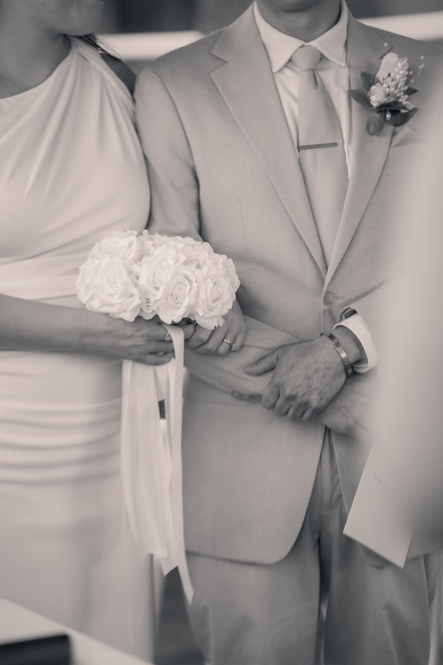 Black and white wedding detail photos showing formal attire and floral boutonniere arrangements.