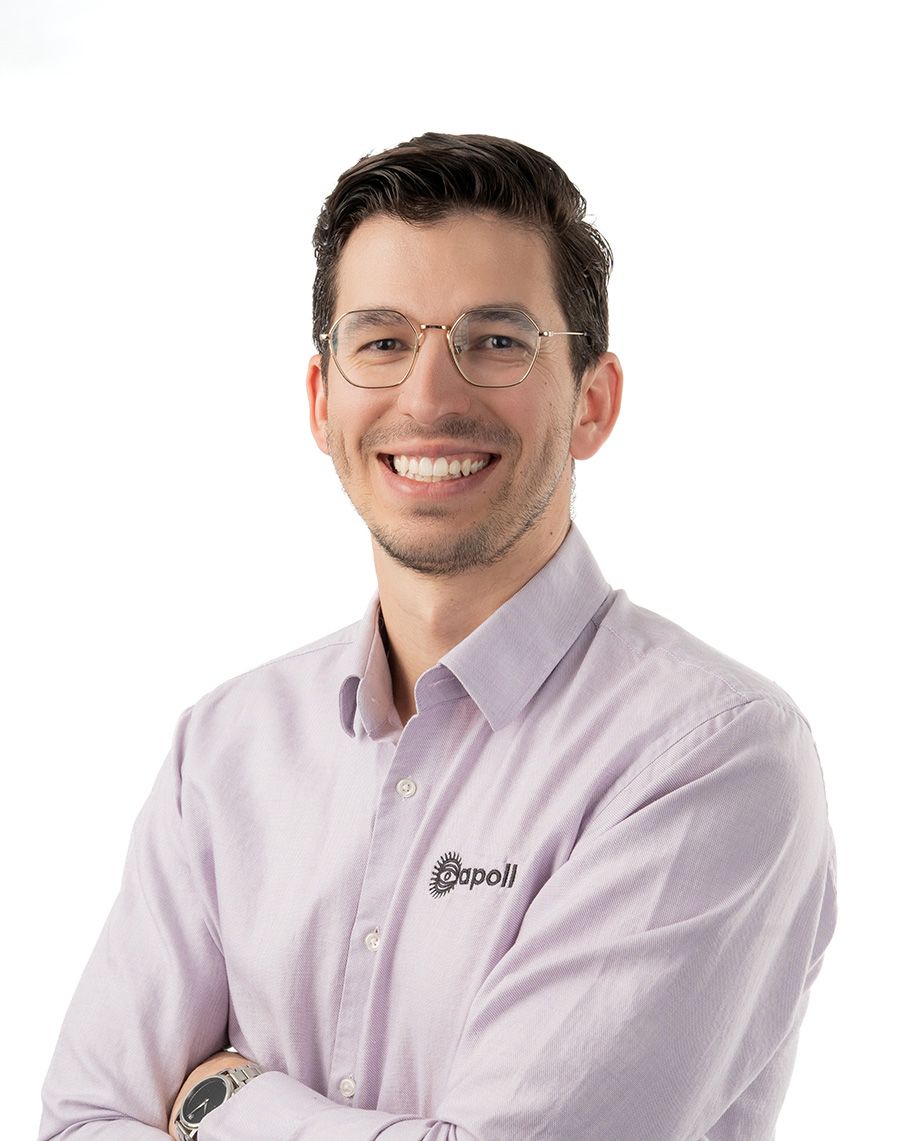 Professional wearing a light colored button-down shirt smiles warmly against a white background.