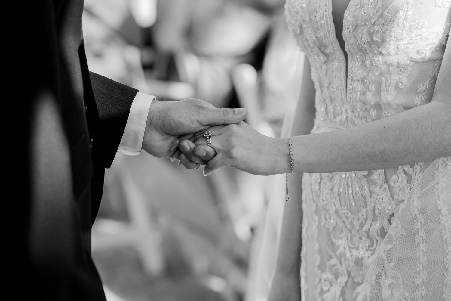 Close-up of hands exchanging wedding rings during ceremony.