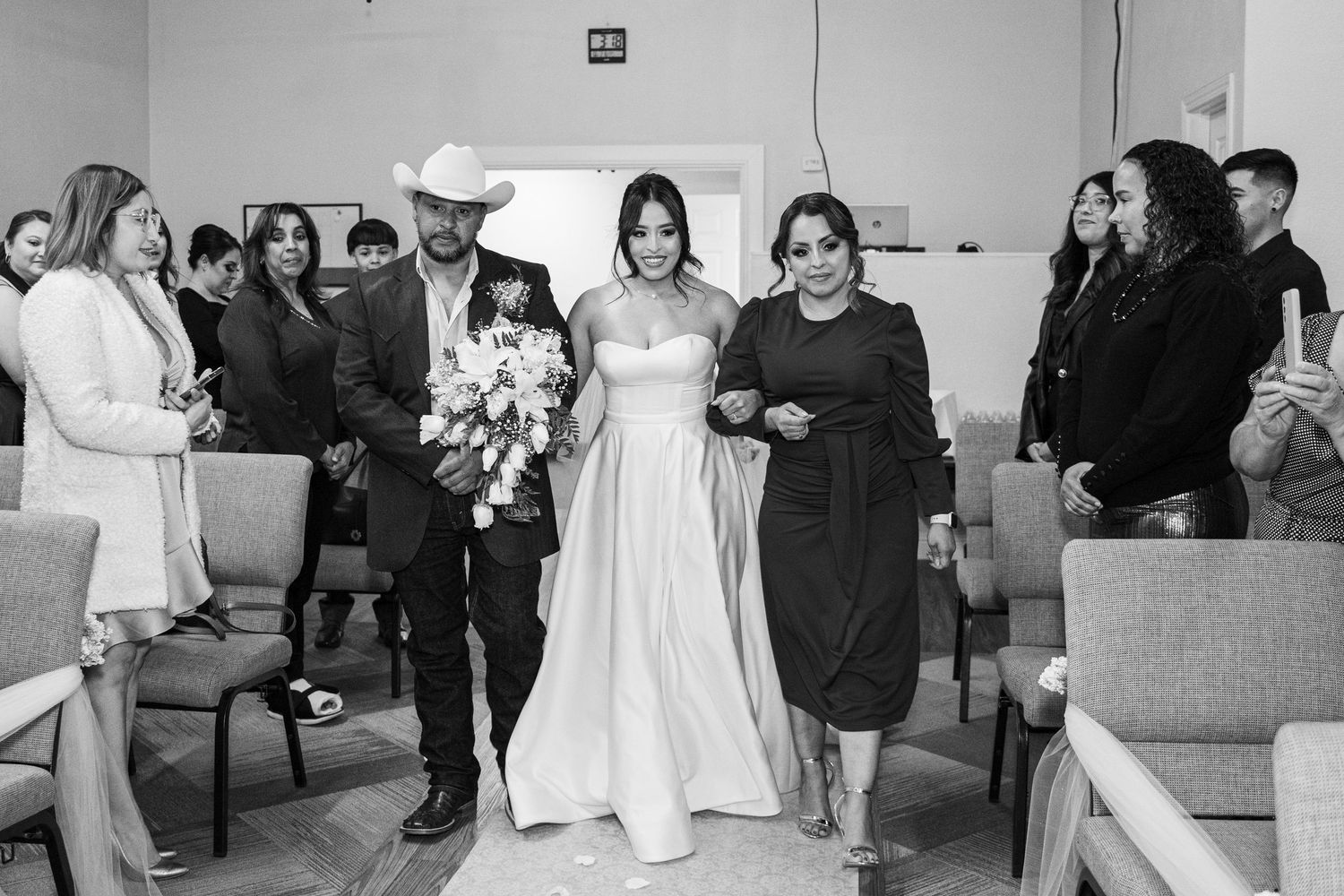 Wedding reception celebration with guests gathered in casual indoor setting.