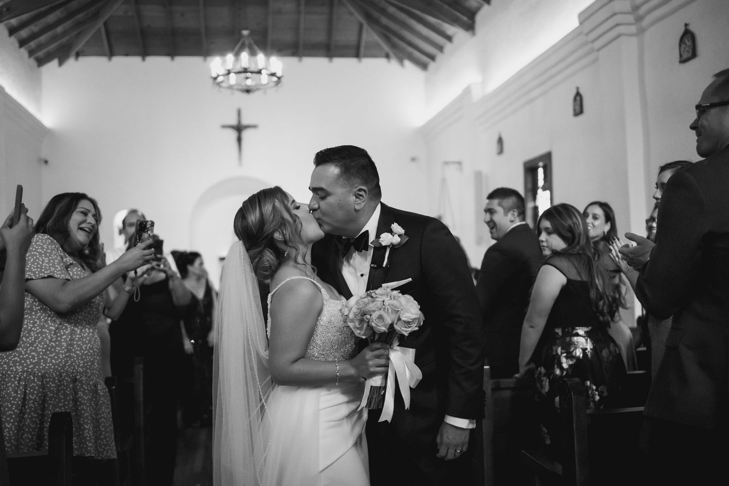 Black and white wedding photo capturing an intimate moment in a chapel.