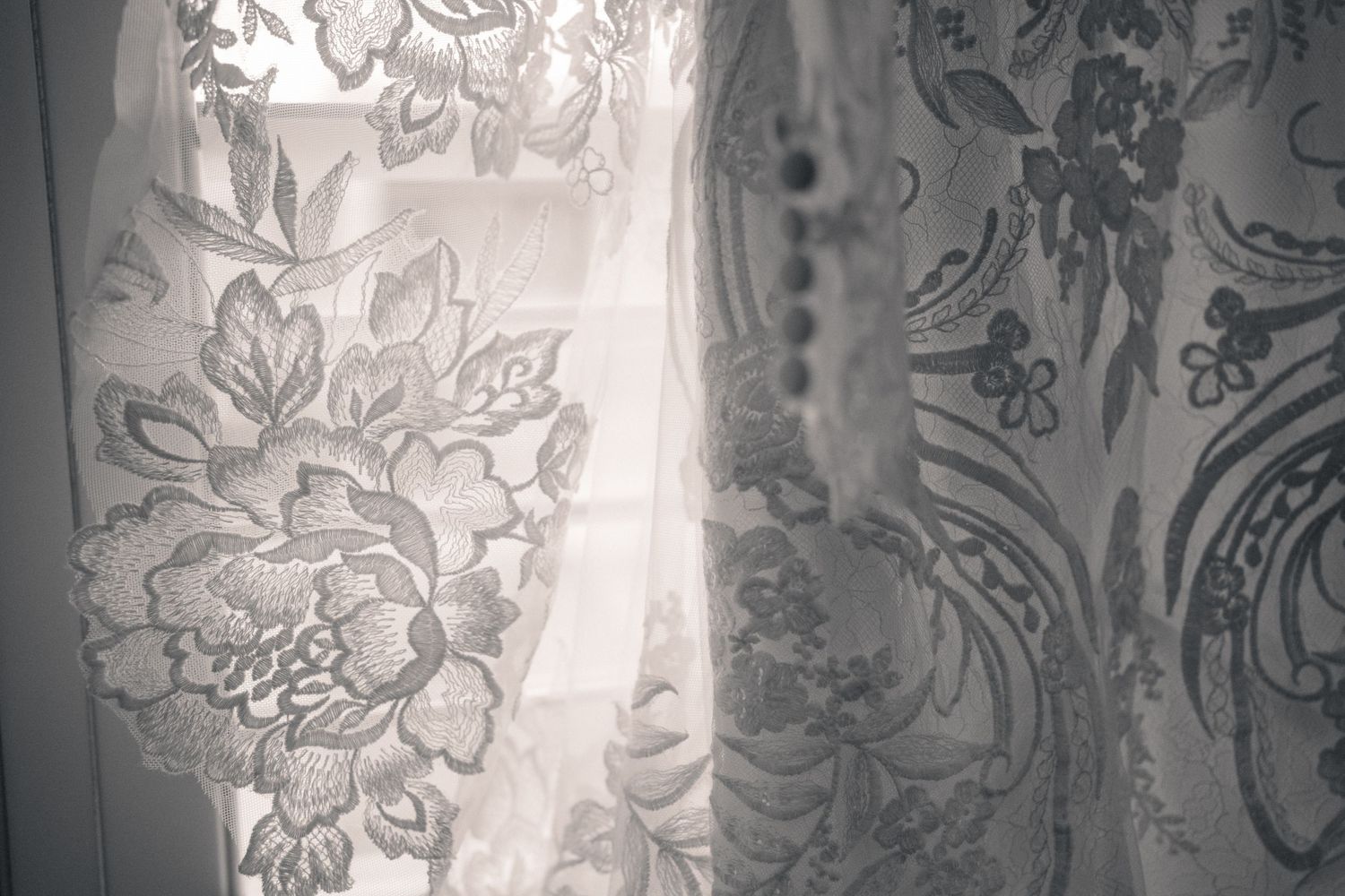 Ornate white floral wallpaper pattern with intricate damask designs and delicate scrollwork details in a vintage style.