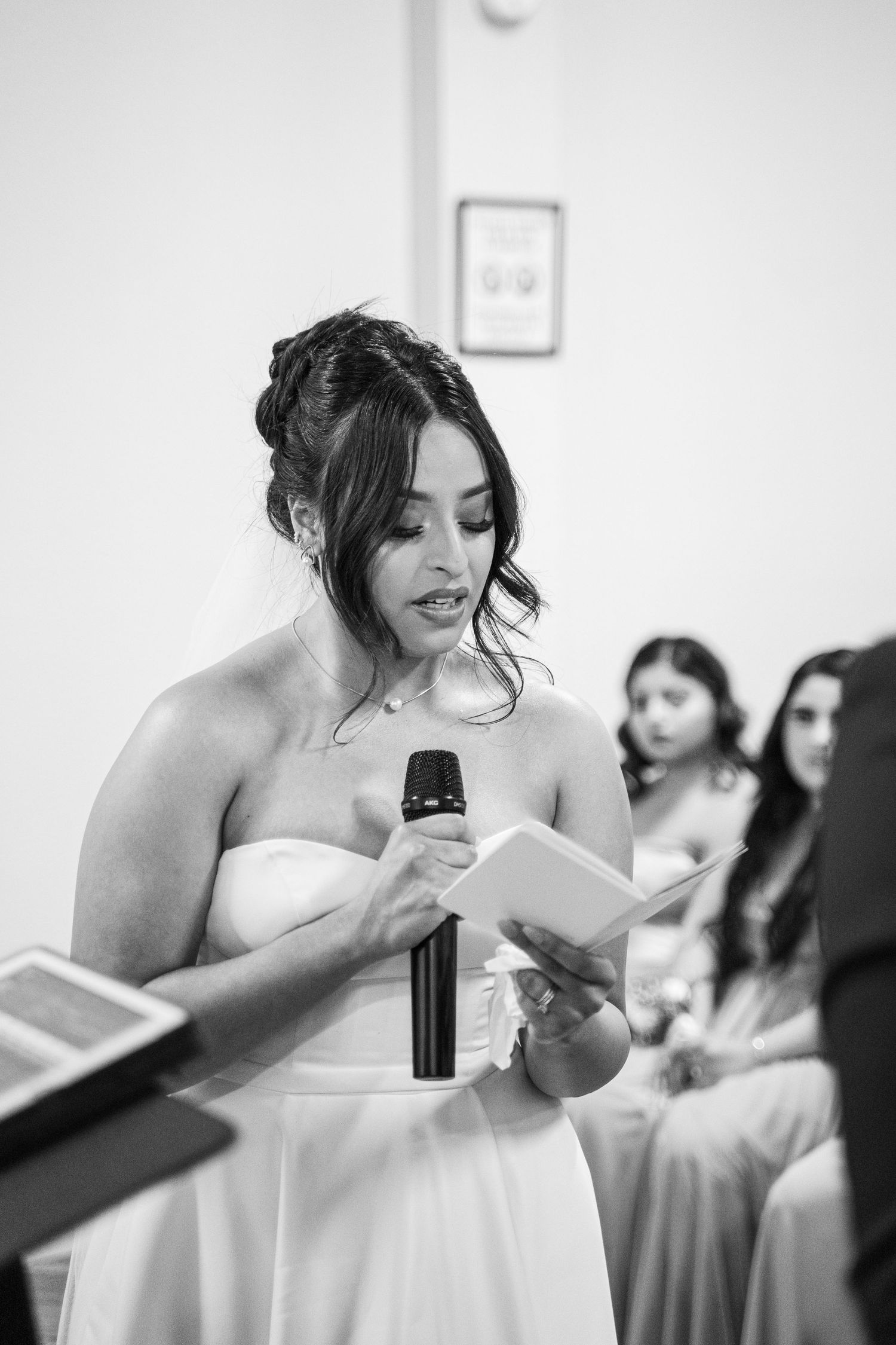 Wedding party member delivering a heartfelt speech from prepared notes.