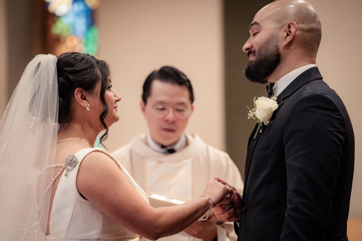 A wedding ceremony in progress with the couple exchanging vows at the altar.