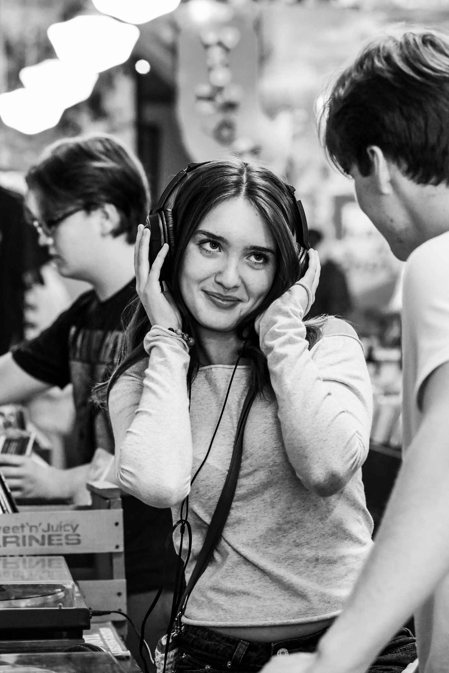 Lovestruck teen gazes to her partner while listening to an electric record player.