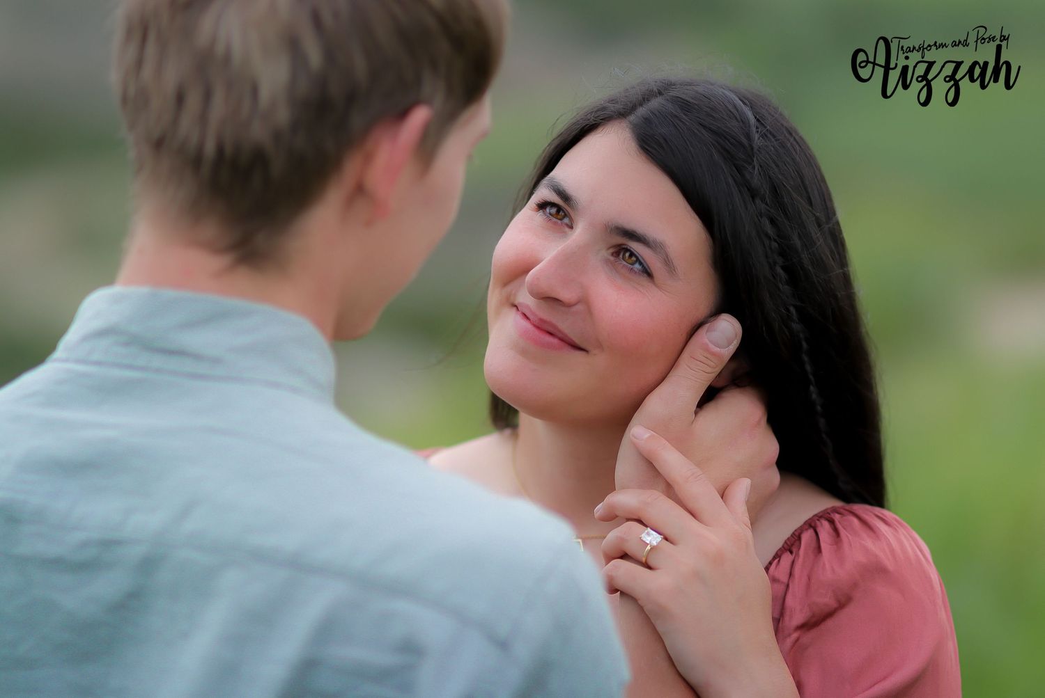 Romantic couple sharing a tender moment outdoors with woman in pink dress and man in blue shirt.