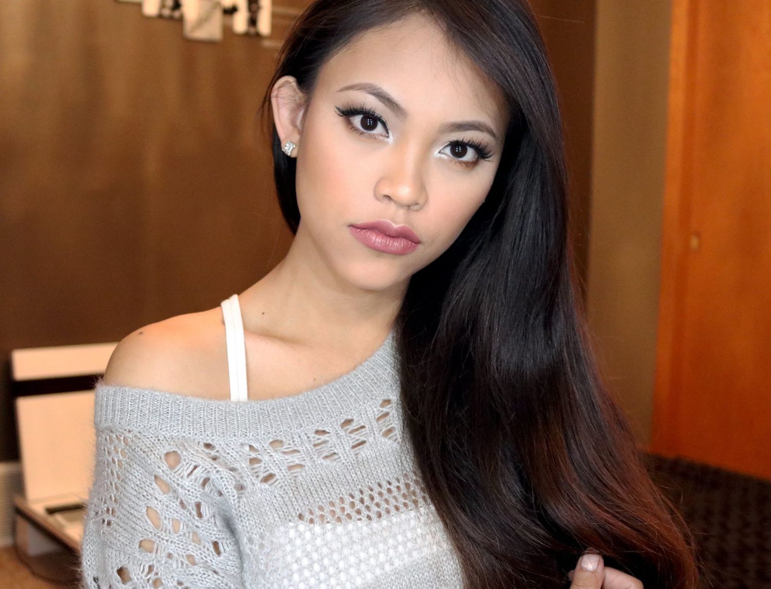 Indoor portrait featuring soft lighting and a casual gray off-shoulder sweater.