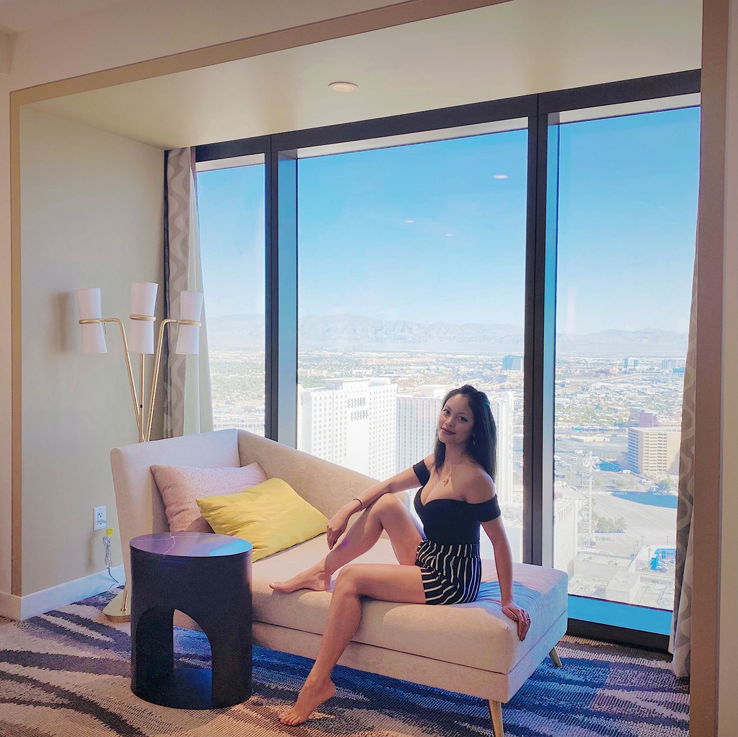 Modern high-rise apartment interior with city views through floor-to-ceiling windows.