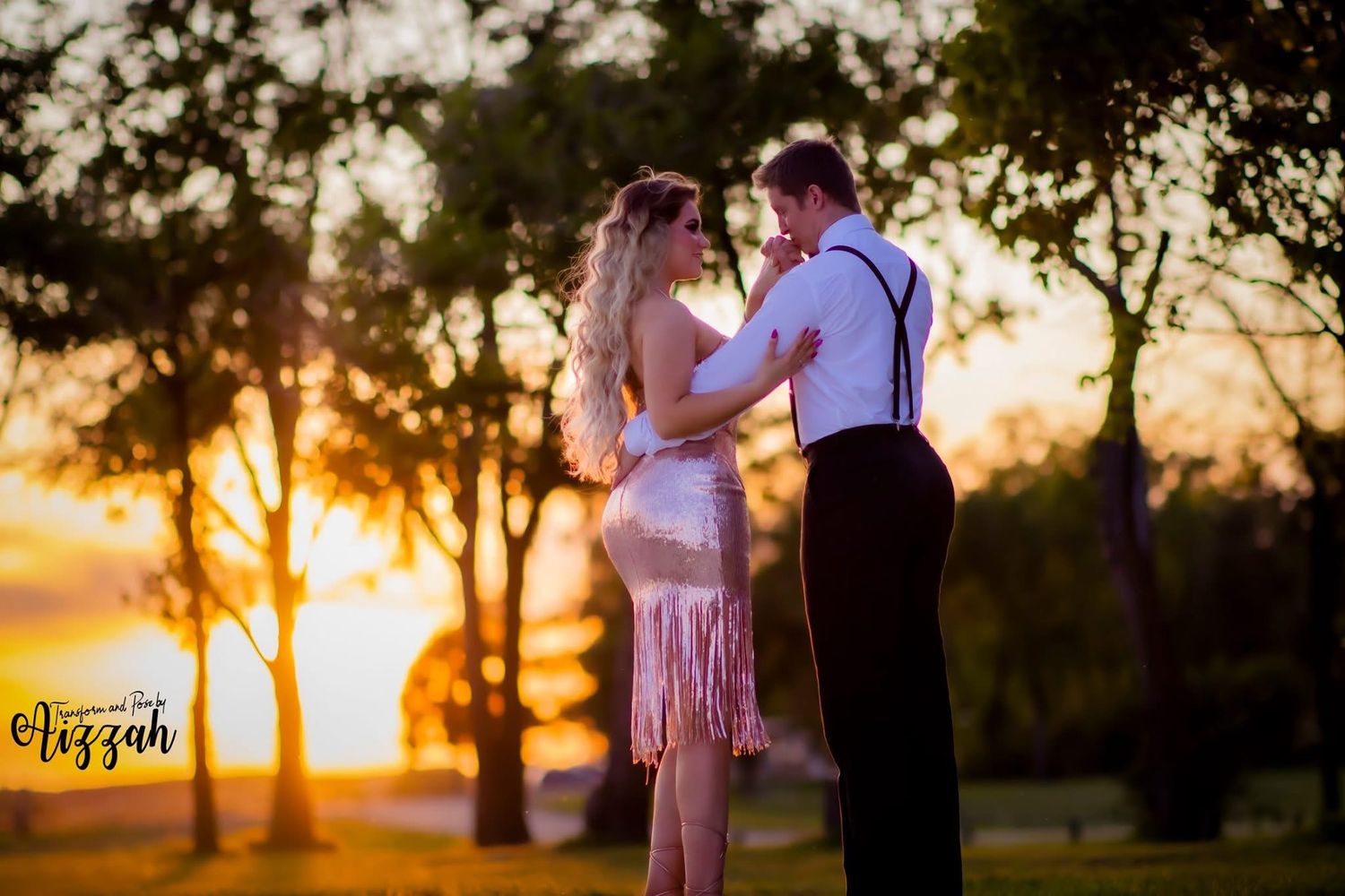 Couple in romantic sunset pose with golden light streaming through trees.
