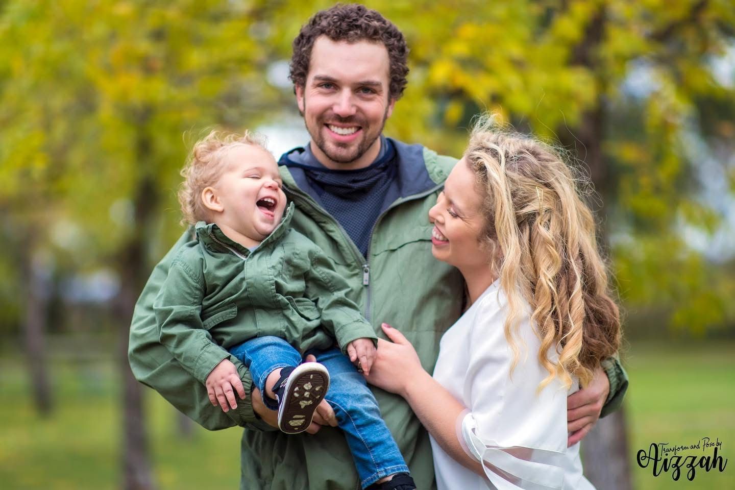 Happy family enjoying a playful moment together outdoors in a park during autumn.