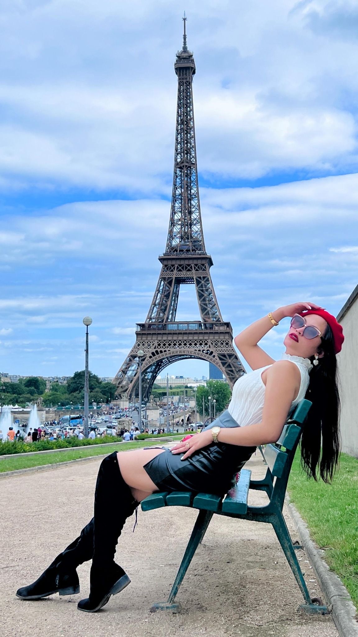 Tourist relaxing on park bench with iconic Eiffel Tower backdrop in Paris.