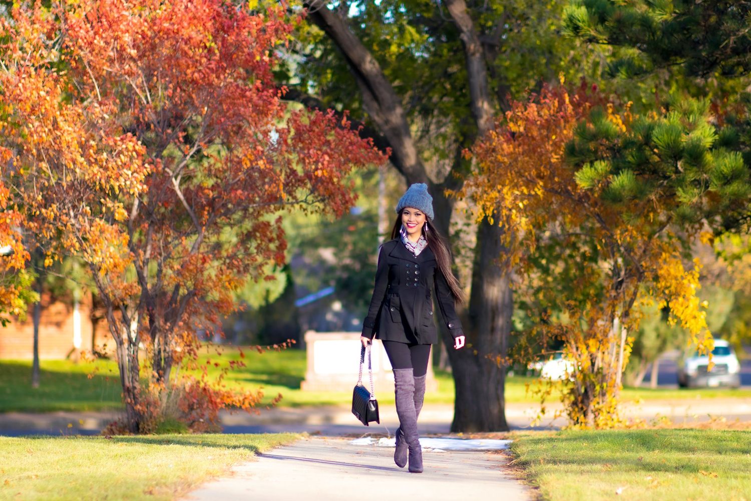 Walking along a path surrounded by vibrant autumn foliage on a sunny day.