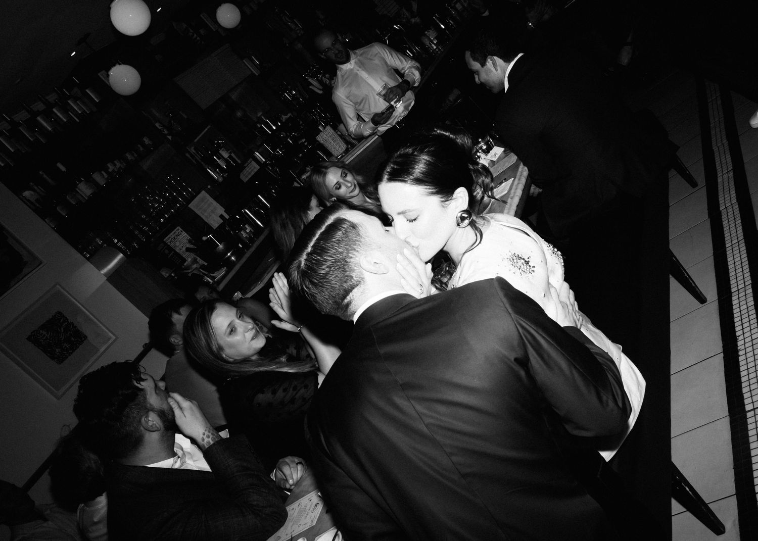 Black and white photo of couple sharing a kiss.