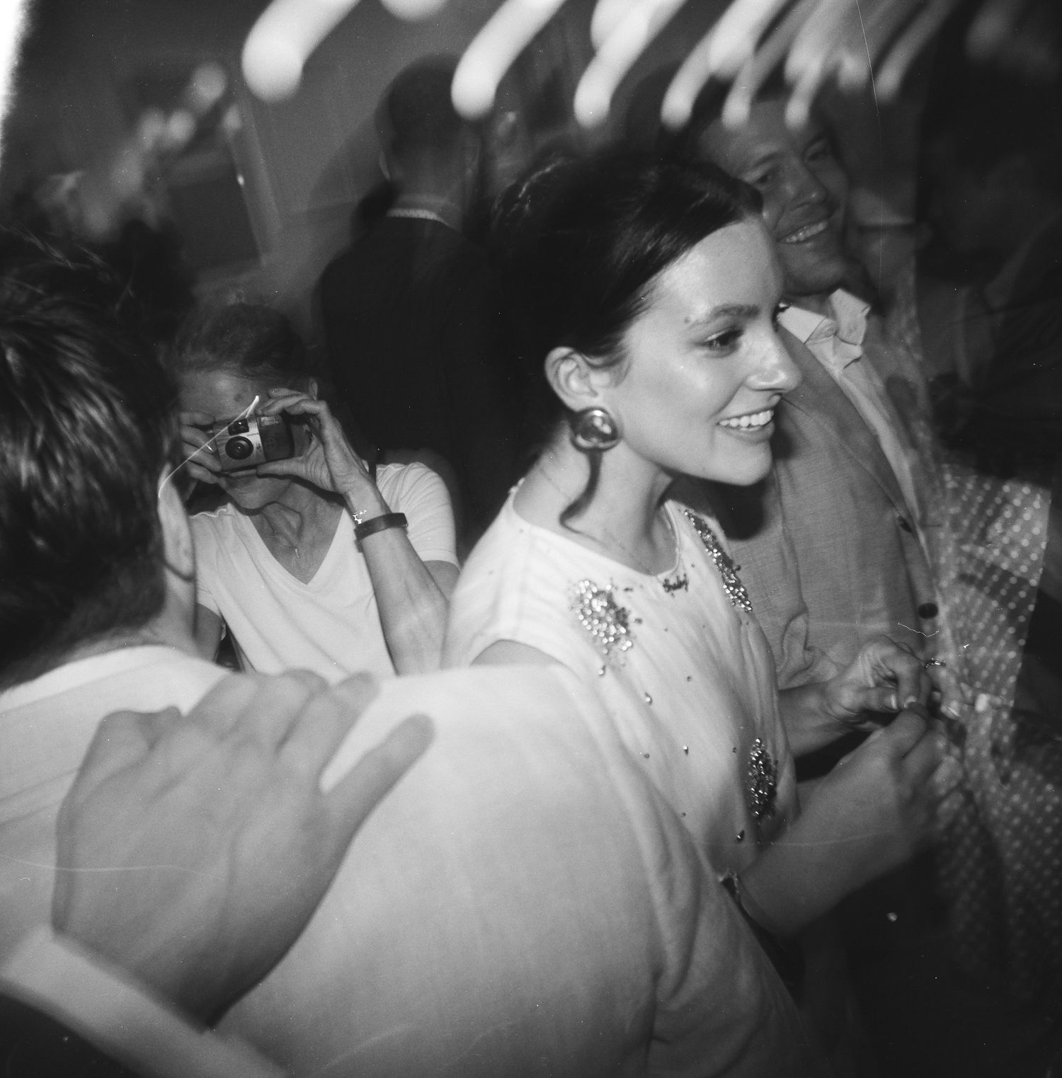 A candid black and white shot of people mingling at a party, captured on 120 film with a Holga 120.