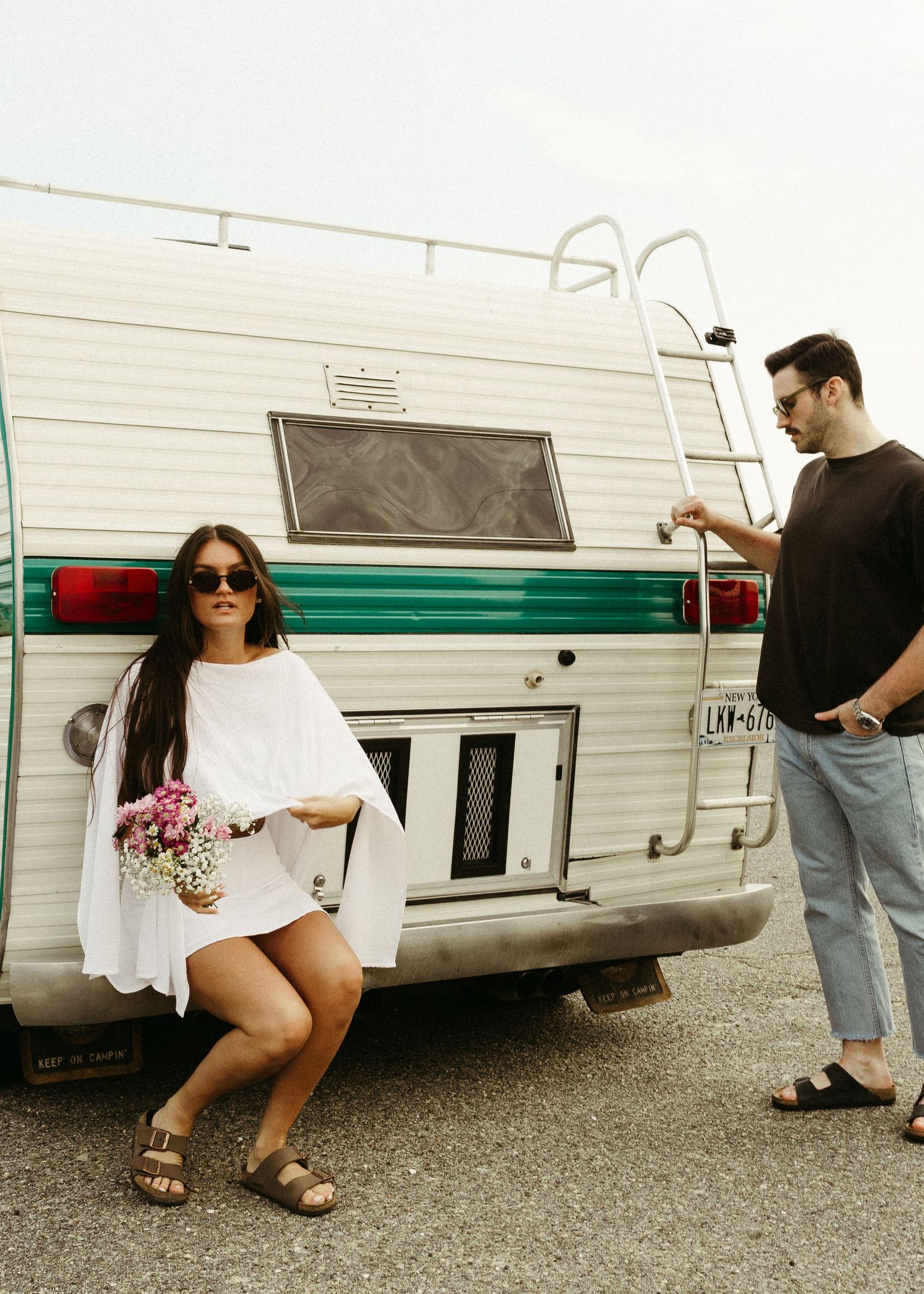 A retro camper serves as backdrop for a casual summer photoshoot.