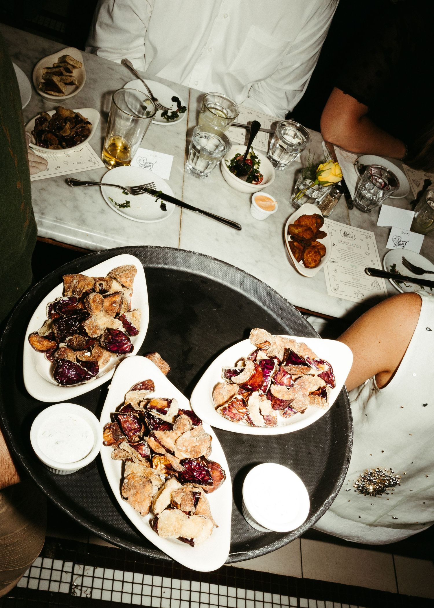 Overhead shot of appetizer plates with assorted meats and seafood on a round serving tray.