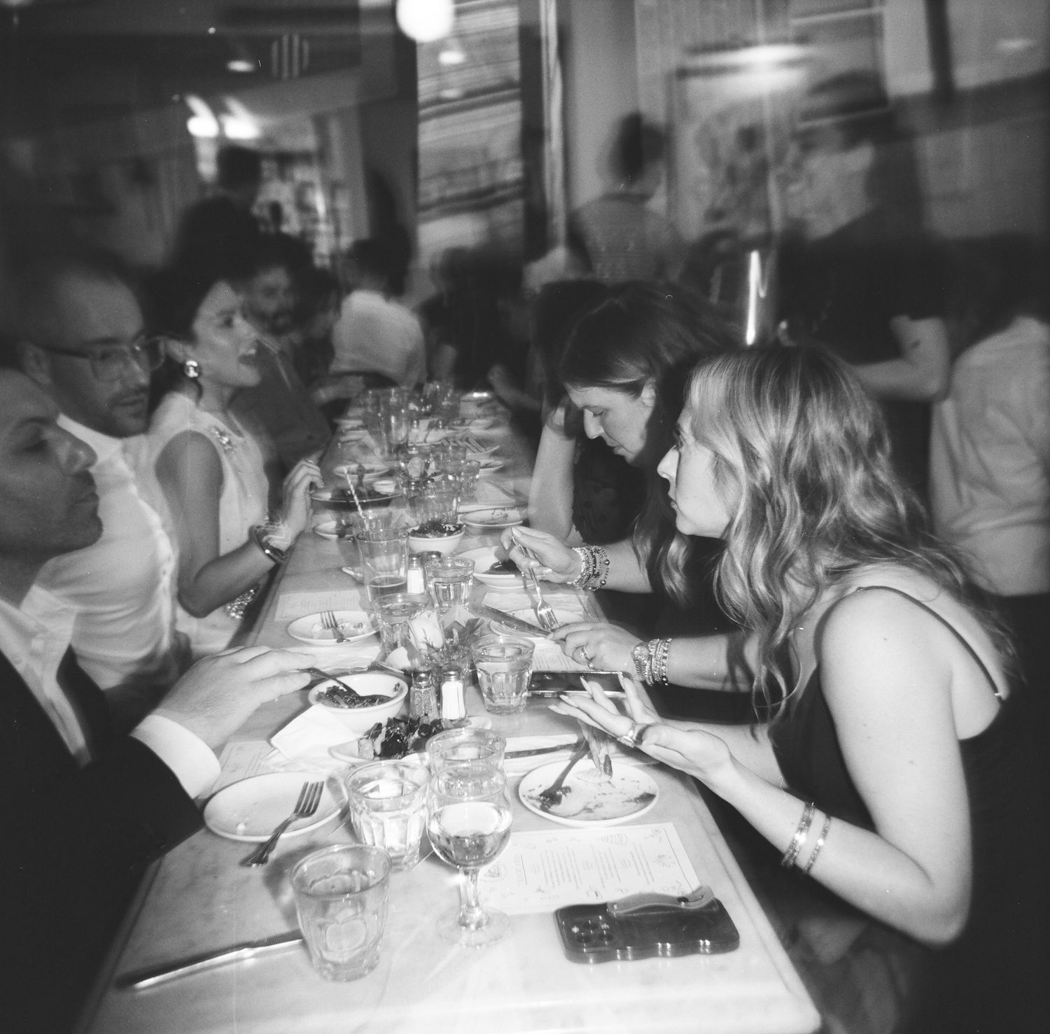 Restaurant guests dining at a long table with menus and wine glasses, captured on 120 film with a Holga 120.