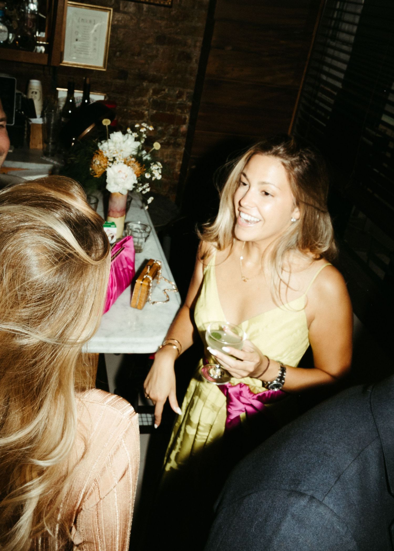 Candid party scene at a dimly lit restaurant with people socializing.