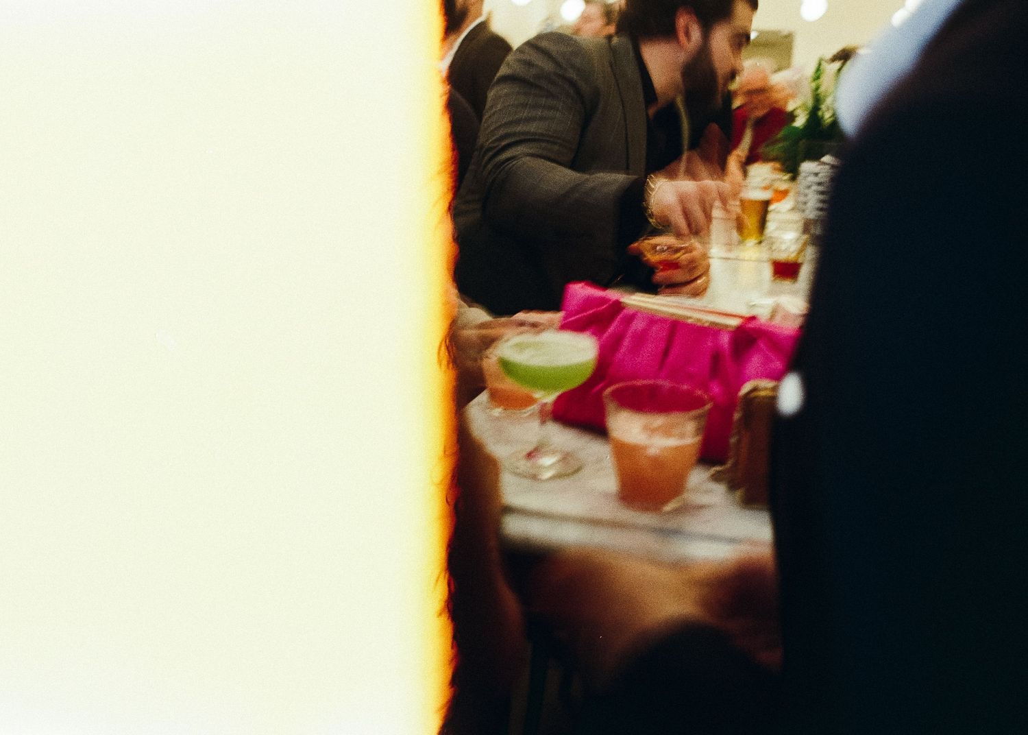 Blurred film candid shot of people dining at a restaurant table with warm lighting.