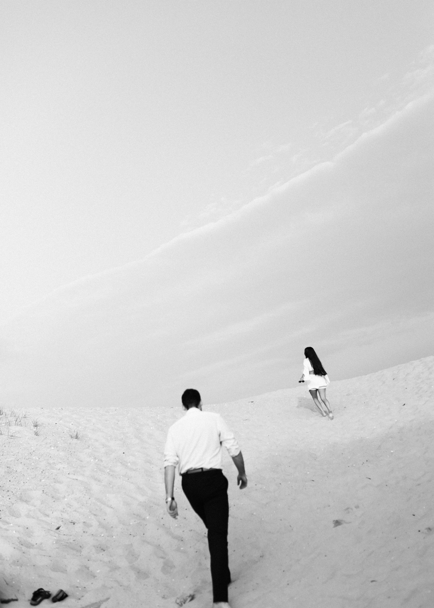 A romantic seaside wedding portrait at sunset with warm golden light.