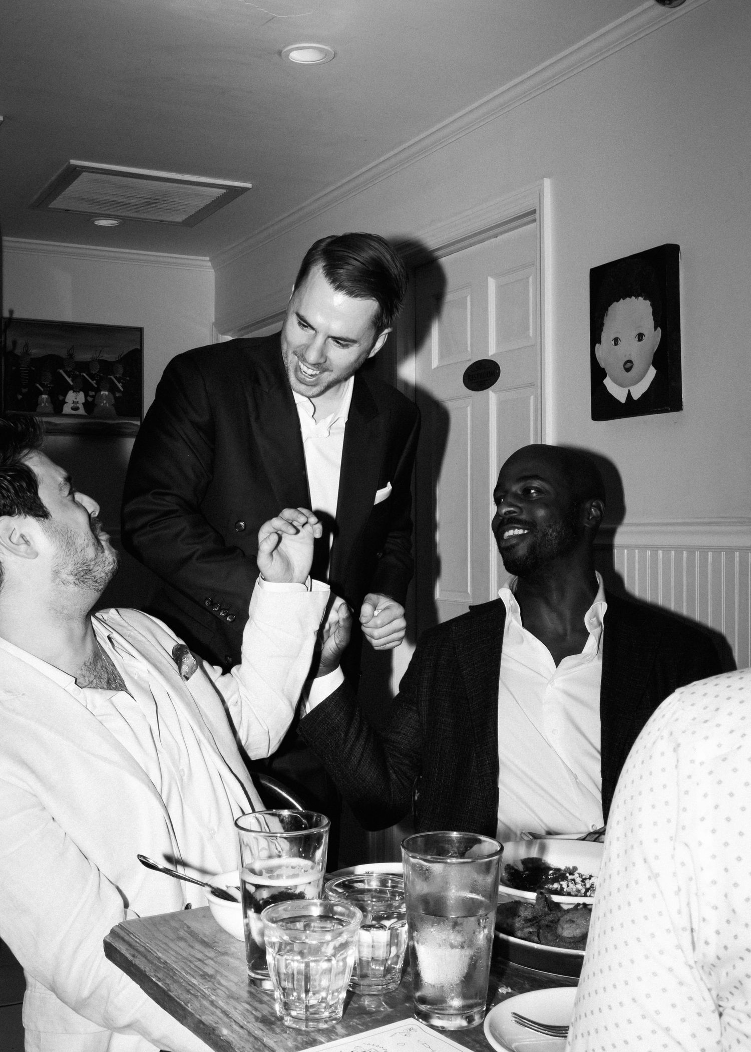 A lively dinner party scene with guests laughing and socializing around a table.