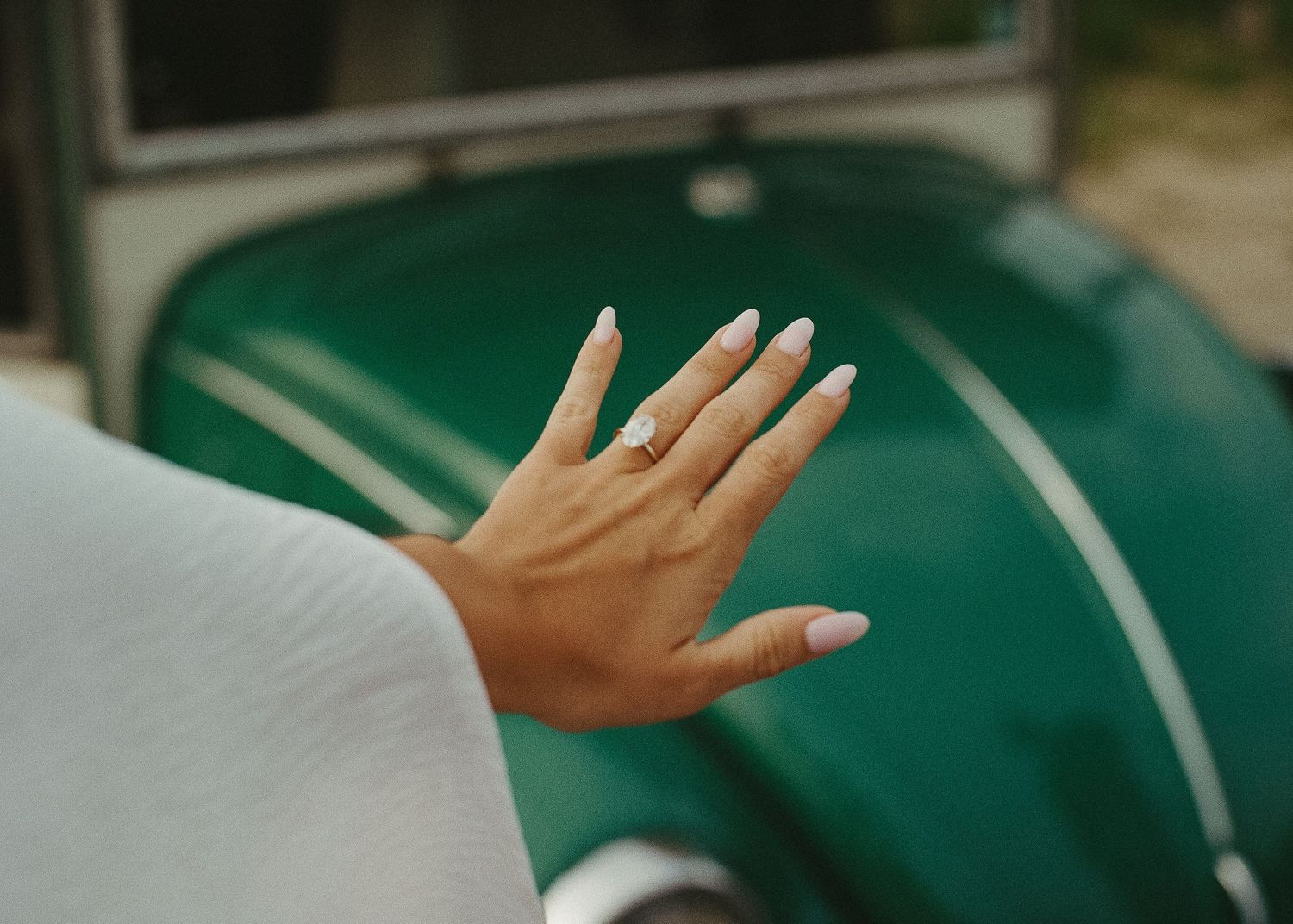 Close-up of hands gesturing against a blurred green background.