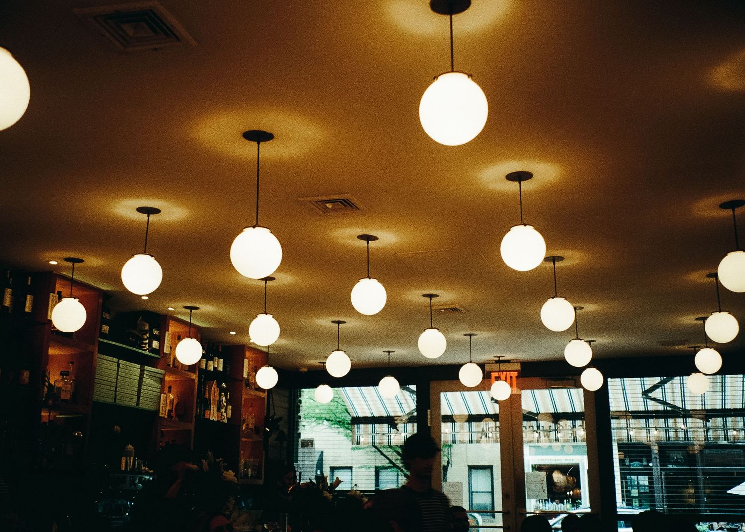 Restaurant interior with rows of white globe pendant lights creating warm ambiance.