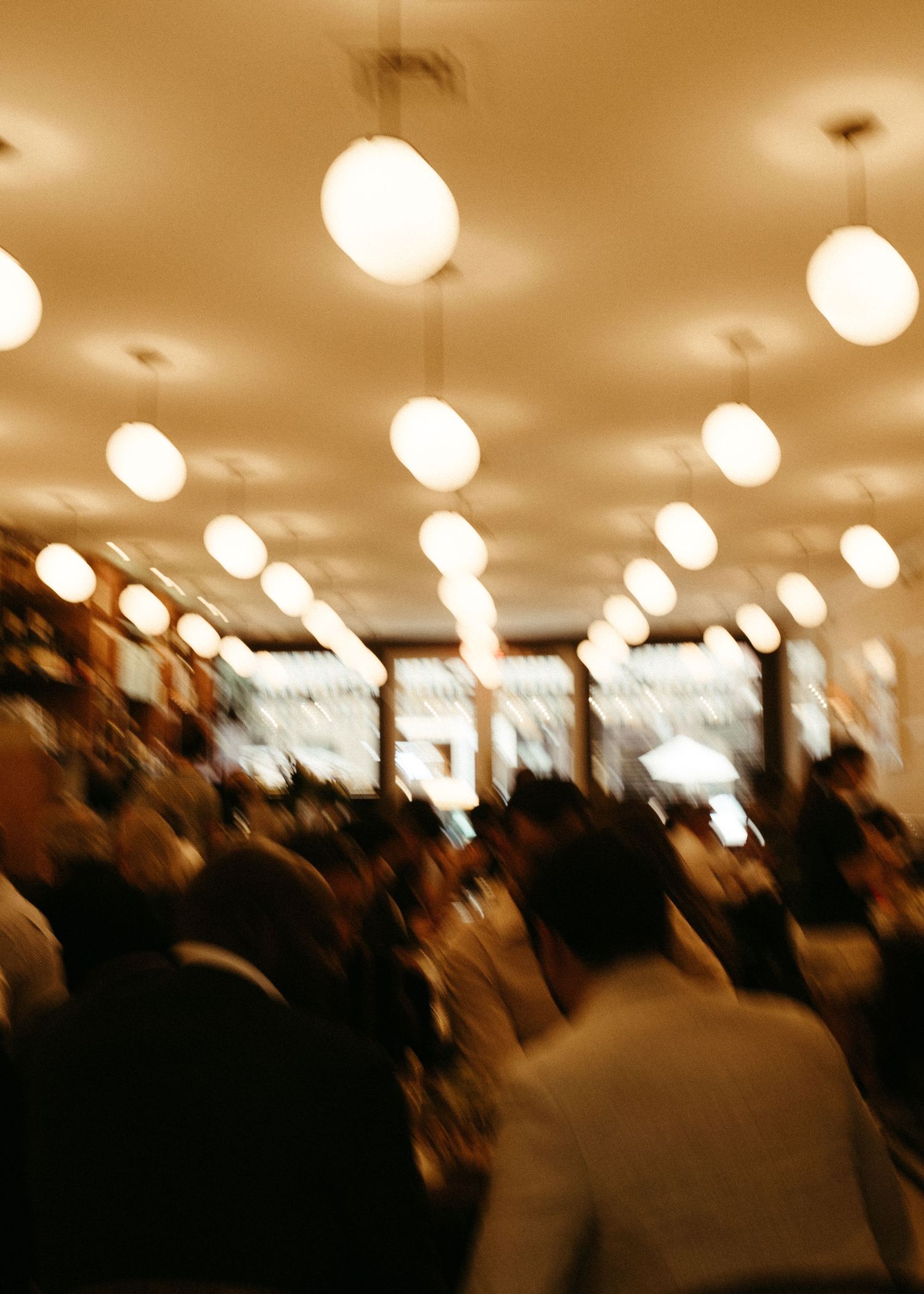 Blurred restaurant interior with rows of glowing globe pendant lights creating ambient atmosphere.