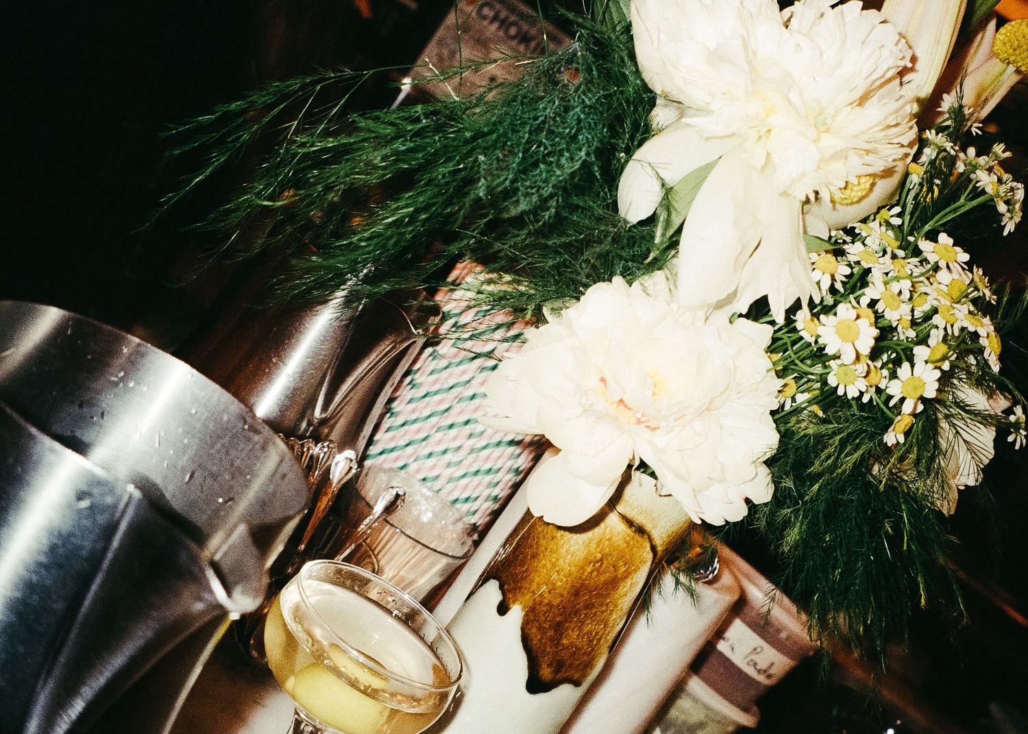 Closeup of flowers and drinks on a table at an evening event, captured on 120 film with a Holga 120.